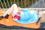 SEXY MONE wearing a hot red shiny nylon shorts and a lightblue shiny nylon rain jacket lolling on the floor of her balcony (Pics)