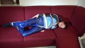 Lucy tied and gagged on a red sofa wearing a supersexy blue shiny nylon pants and a blue rain jacket (Video)