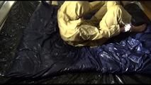 Pia tied, gagged and hooded lying on a bed wearing sexy golden rainwear (Video)