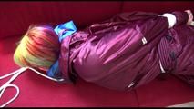 Mara tied and gagged on a red sofa wearing a sexy shiny bordeaux red oldschool skibib (Video)