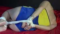***NEW MODELL MIA*** wearing a sexy yellow/blue shiny nylon shorts and a yellow top being tied and gagged with ropes and a clothgag on a bed (Video)