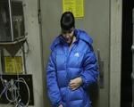 Jill in a cold room wearing shiny nylon rain pants and a down jacket (Video)